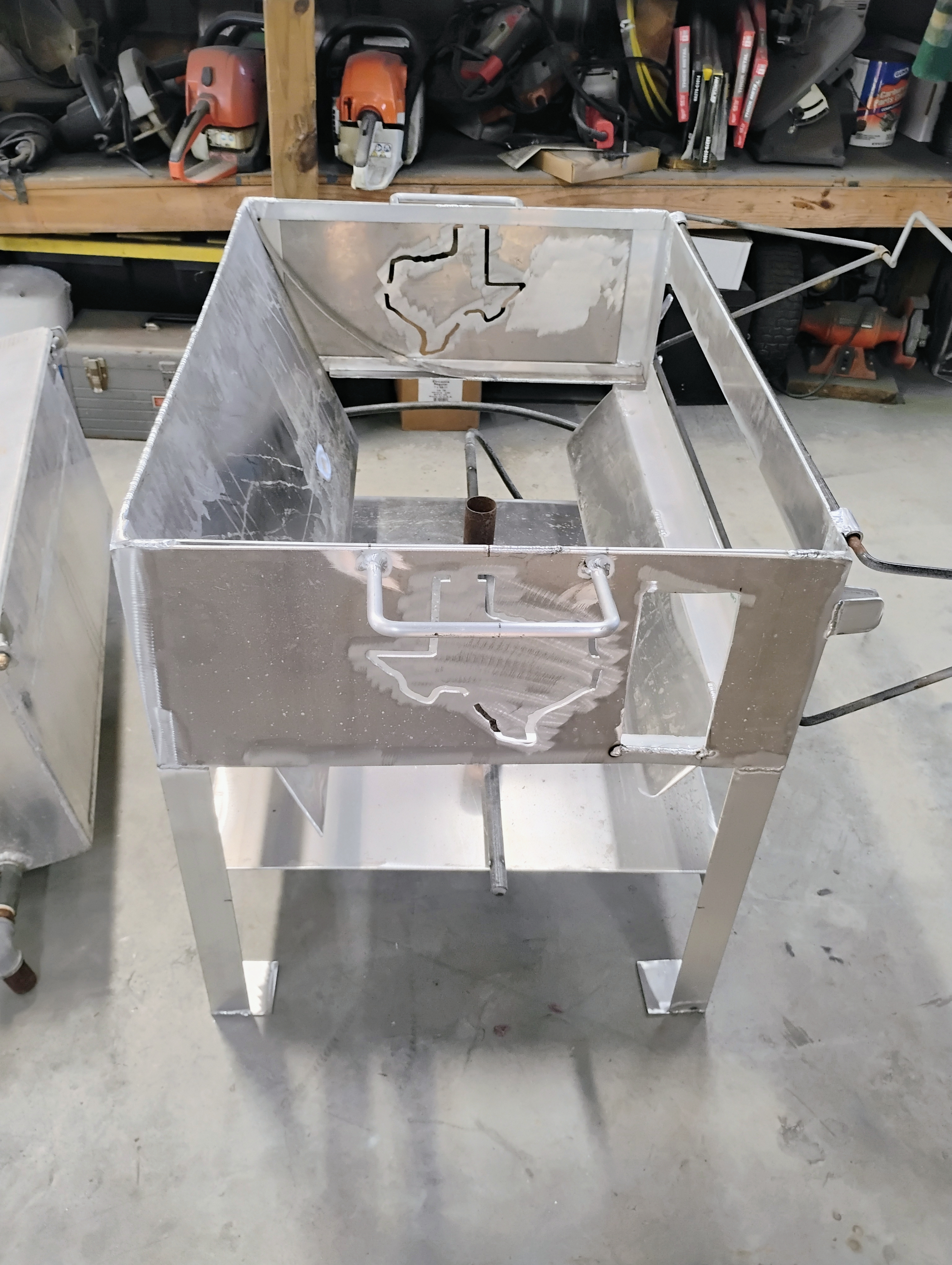 Front view into stainless cooker showing burner tubes and internal partitions